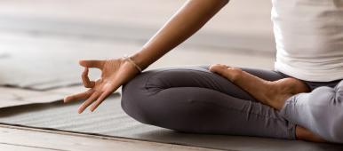 Yogi black woman practicing yoga lesson, breathing, meditating, doing Ardha Padmasana exercise, Half Lotus pose with mudra gesture, worki...